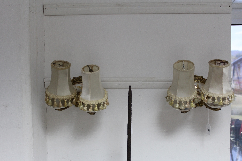 A pair of brass & ceramic twin-branch wall lights, with shades, 8½" x 5".