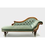 An early Victorian carved mahogany frame chaise longue with buttoned scroll end & arm support, on