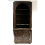 254. An 18th century oak standing corner cabinet, the upper part with rounded top & four shaped