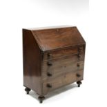 A late George III mahogany bureau with sloping fall front enclosing fitted interior, four long