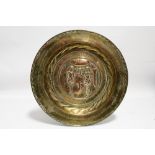 An embossed brass alms dish with figures of Adam & Eve in the Garden of Eden to the centre; 14½”