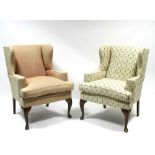 A pair of upholstered wing-back armchairs with flat scroll arms, loose cushion seats, & on