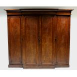 A Victorian mahogany break-front wardrobe with cavetto cornice, the centre fitted four sliding trays