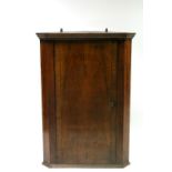 A walnut hanging corner cupboard enclosed crossbanded panel door; 34" wide x 47½" high.