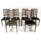 A set of six Edwardian inlaid mahogany rail-back dining chairs with padded seats & on square tapered