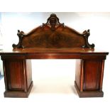 A mid-Victorian mahogany pedestal sideboard with carved scroll border to the raised panel back,