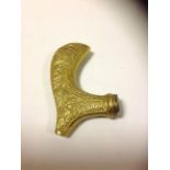 A brass stick handle, with foliage desig