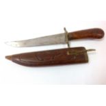 A carved handled dagger in a carved wood