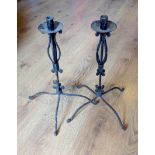 A pair of four legged iron candlesticks