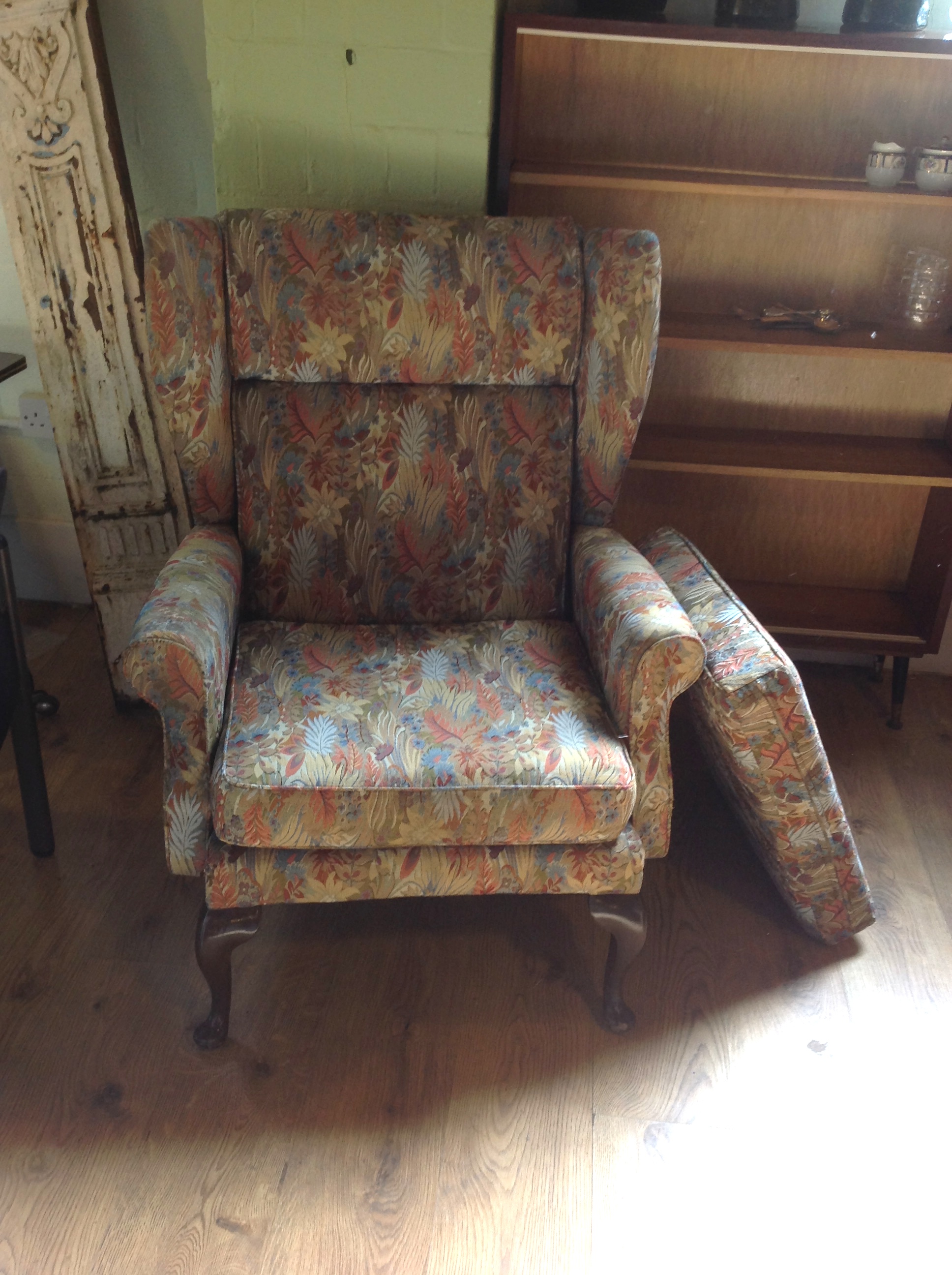 An upholstered wing back armchair, plus