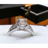 A 1.55 Carat VVS1 rare white + (f) emerald cut Diamond ring, with Diamond shoulders in 18 Carat