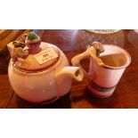 An unusual, handmade, pink pottery teapot and mug, with frogs climbing up the outside and one in the