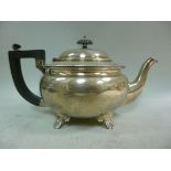 A silver teapot of squat, bulbous form w