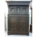 An 18thC and later carved oak cupboard,