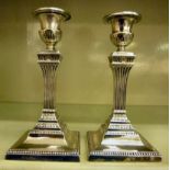 A pair of loaded silver candlesticks wit