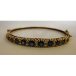 A 9ct gold hinged bangle, set with alter