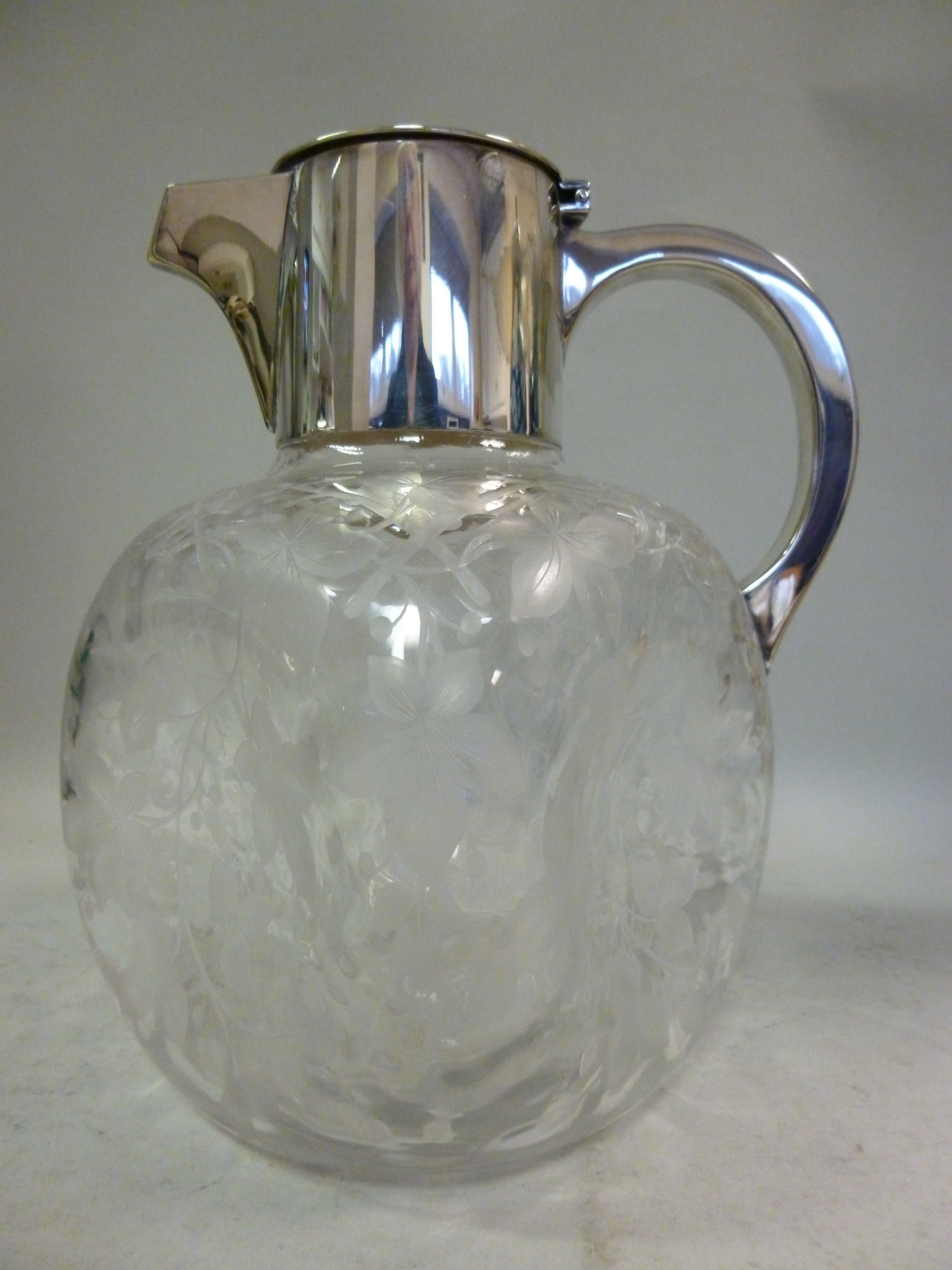 An early 20thC glass wine jug of dimpled