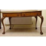 A mid 20thC walnut writing table, the to