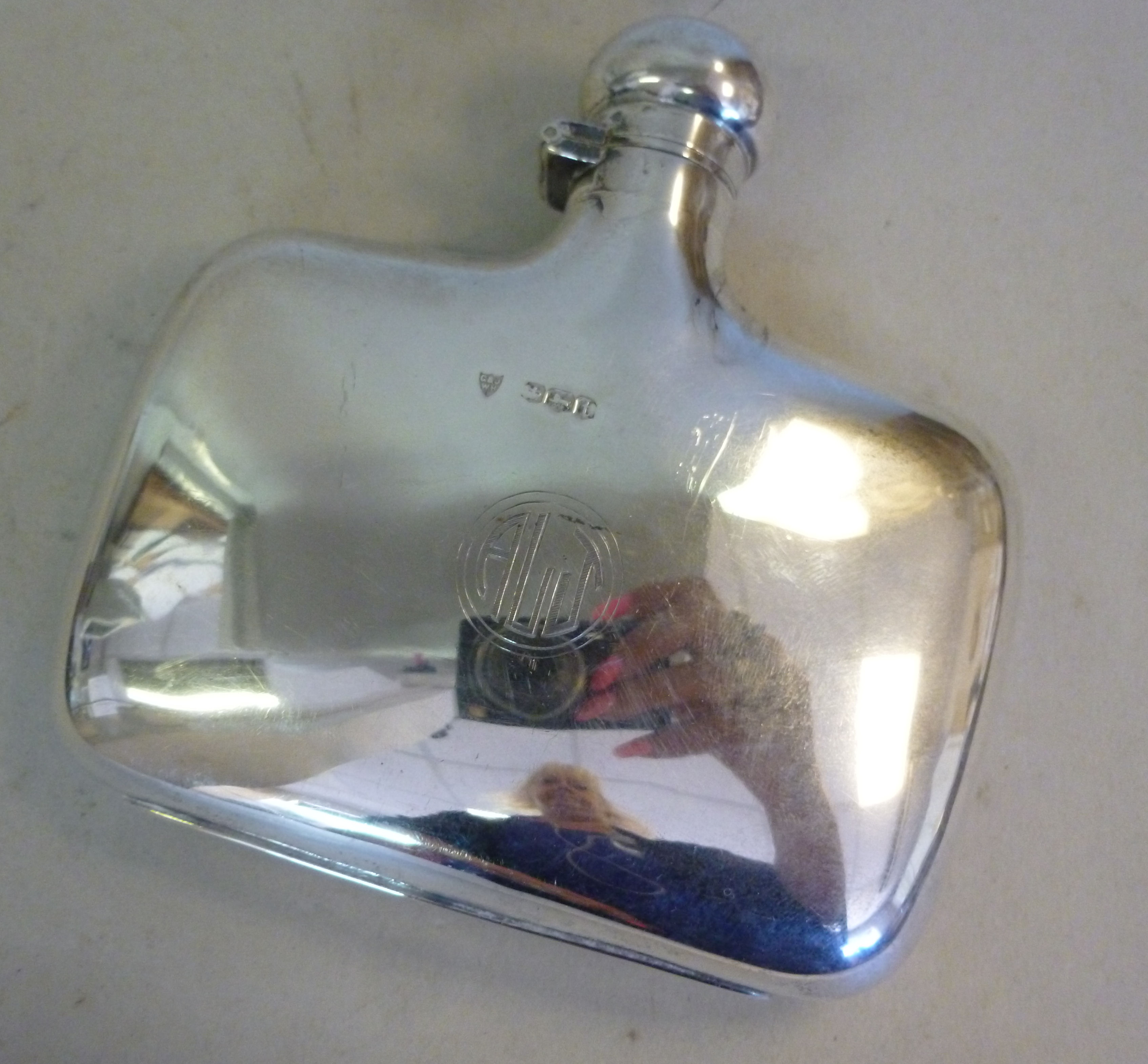 A silver hip flask of cushion form with