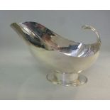 A silver sauce boat, having a flared lip