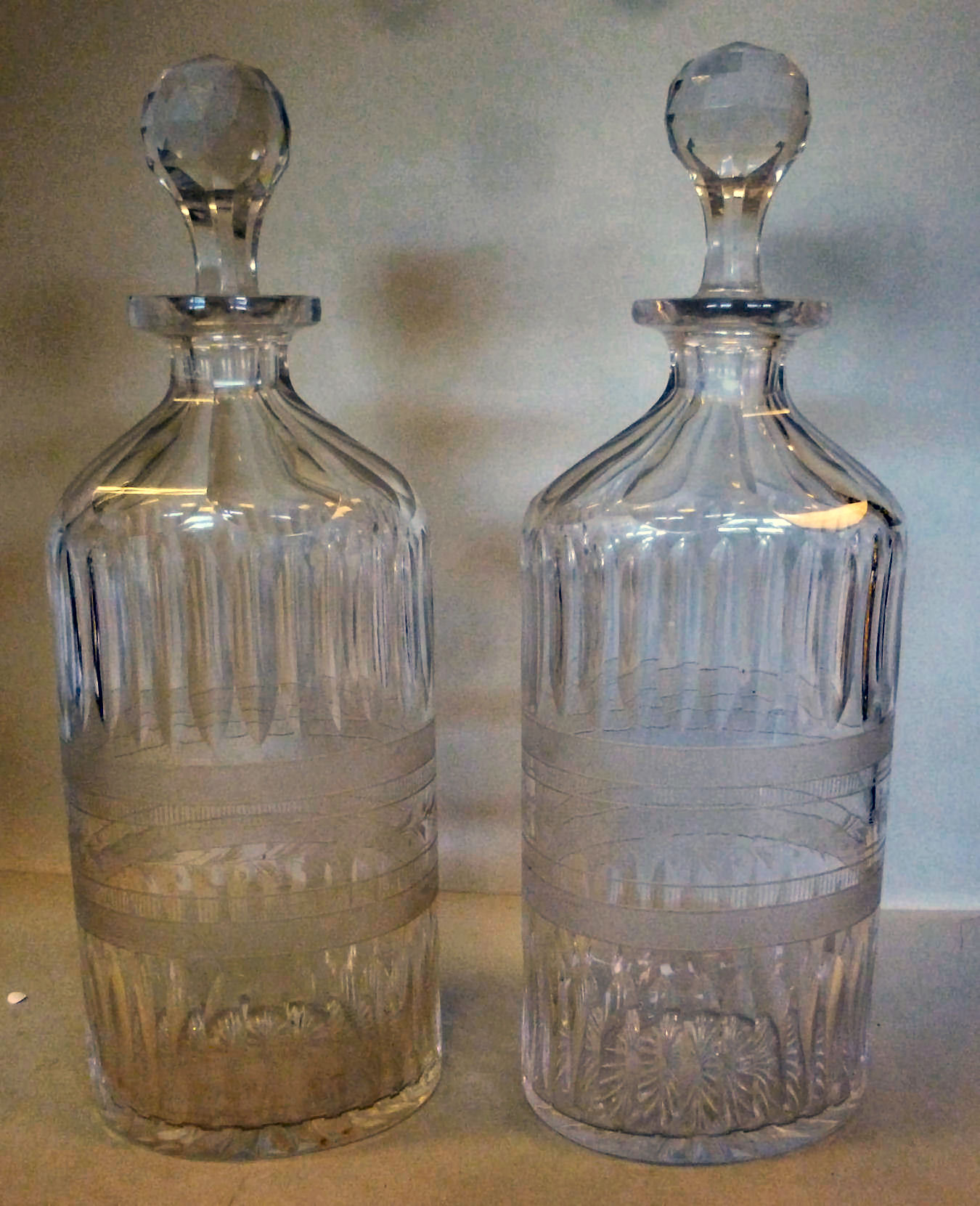 A pair of Edwardian clear glass decanter