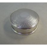 A silver pill box of circular form, havi