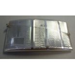 A silver card case of curved design, the