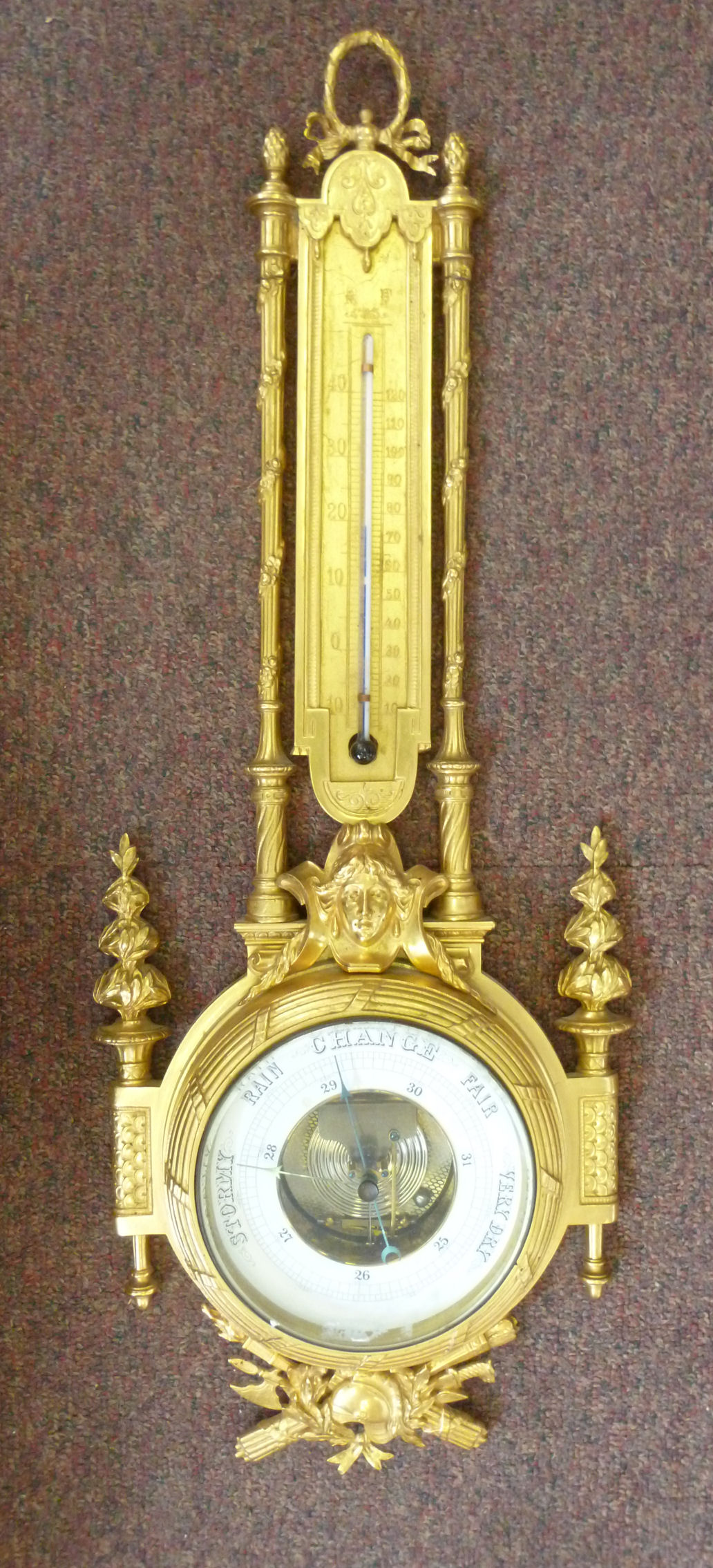 A late 19thC gilt brass barometer, ornat