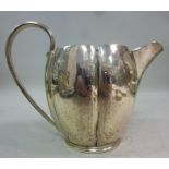 A silver cream jug of segmented ovoid fo