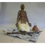 A Geschutzt Bergman cast and cold painted bronze figure, a Nubian kneeling on a rush mat, his arms