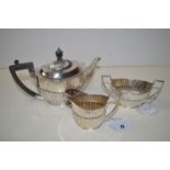 A three-piece silver tea service, by W.S.C.S., London 1902, of oval half fluted form, 19oz gross.