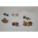 A pair of white stone and yellow metal earrings; a pair of sapphire and diamond cluster earrings;