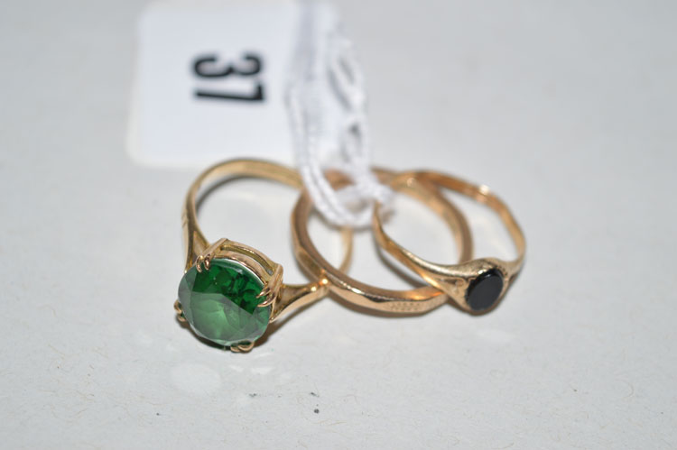 A green paste stone ring in double claw setting, on 9ct. yellow gold shank; an onyx set ring on 9ct.