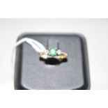 An emerald and diamond ring, the oval facet cut emerald four claw set,