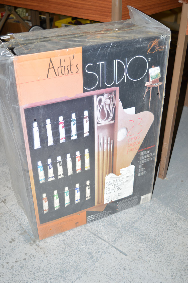 An artist's studio easel with paints, brushes, etc.