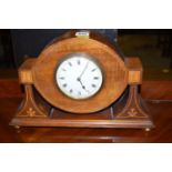 An Edwardian mantel clock in ornate shaped and inlaid mahogany case.