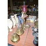 A Victorian table oil lamp with cranberry coloured damaged shade,