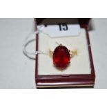 A synthetic ruby ring, the oval facet cut synthetic stone measuring 17.6 x 13 x 7.