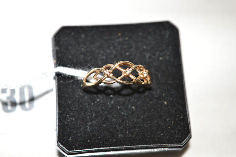 An openwork 9ct. gold ring set three small diamonds, ring size O.