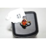 A hessonite garnet ring, the oval facet cut stone claw set within crossover mount, on 9ct.