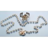 Chanel: a faux pearl necklace with flower pattern pendant;