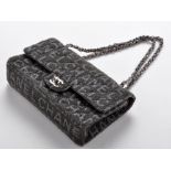 Chanel: a fabric flap bag, with metal and leather shoulder strap,