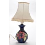 William Moorcroft: a hibiscus pattern table lamp, with dark blue ground of baluster form,