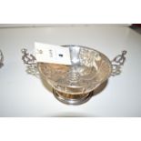 A silver two handled bon bon dish embossed with foliate panels,