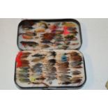 A selection of trout and sea trout wet flies contained in a black rectangular weekly fly box.