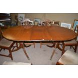 A reproduction mahogany extending dining table, the crossbanded top with reeded edge,