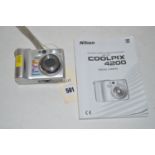 A Nikon Coolpix 4200 digital camera, with an instruction book.