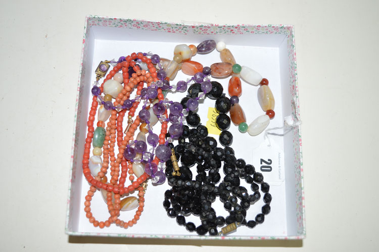 A jet necklace; an agate necklace; a coral necklace; and a purple stone necklace.