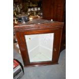 A stained wood hanging corner cabinet,