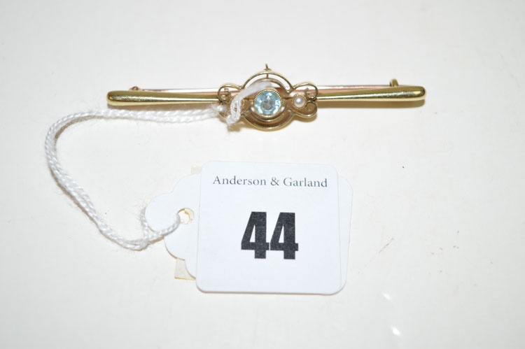 An aquamarine and seed pearl set bar brooch, stamped 15ct.